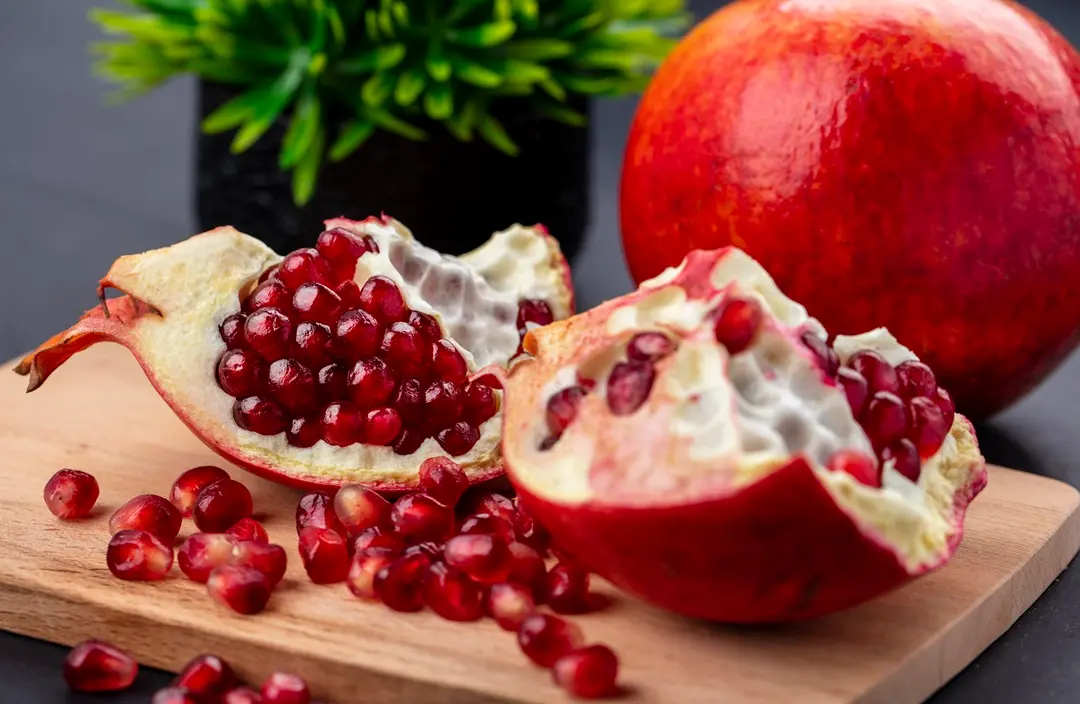 close-up-view-pomegranate-pieces-berries-cutting-board-with-whole-one-black-surface Diszplázia ellen gyulladáscsökkentő étrenddel Sejtvédelem 