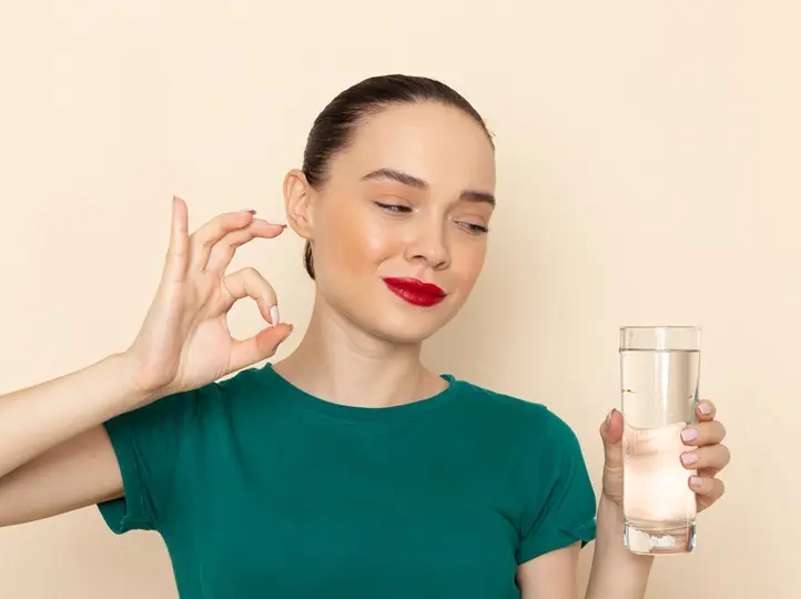 front-view-young-female-dark-green-shirt-blue-jeans-holding-glass-water-smiling-beige Hogyan lehet lelassítani az öregedést? Sejtvédelem 