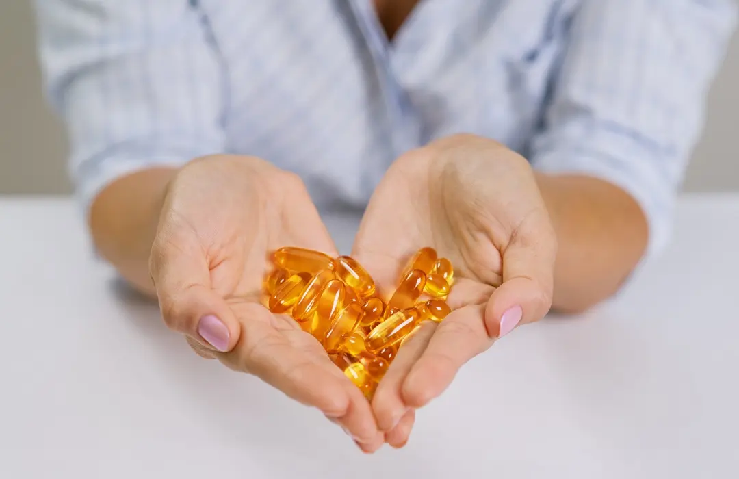 hands-woman-holding-fish-oil-omega-3-capsules Hasfájás stressz miatt: mi történik a szervezetedben? Emésztés 