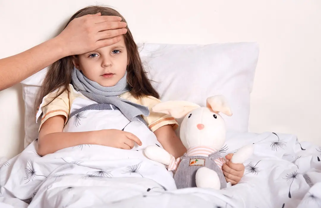 indoor-shot-little-girl-with-fair-hair-lying-her-bed-hugging-favourite-toy-having-unknown-hand-forehead-checking-temperature Hidegben gyakori a krupp - Előzd meg! Immunrendszer 