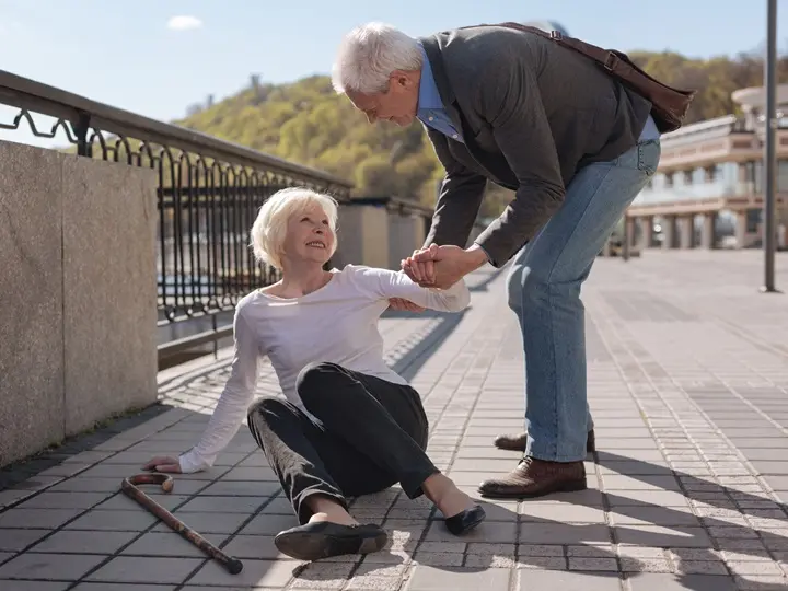 old-pretty-cheerful-woman-lying-ground-smiling-while-polite-husband-helping-her Időskori csonttörések megelőzése tápanyagokkal Szupertápanyagok 