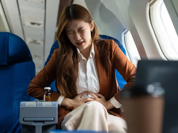 tired-asian-businesswoman-with-headache-feeling-sick-while-sitting-airplane-passengers-near-window Utazási hasmenés megelőzése? Így készülhetsz fel! Emésztés 
