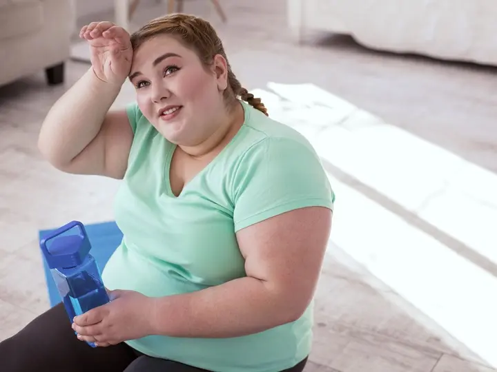 workout-tiredness-red-head-young-woman-sitting-yoga-mat-holding-water-bottle Ingadozó vércukorszint: Ezért nehéz a fogyás! Hormontámogatás 