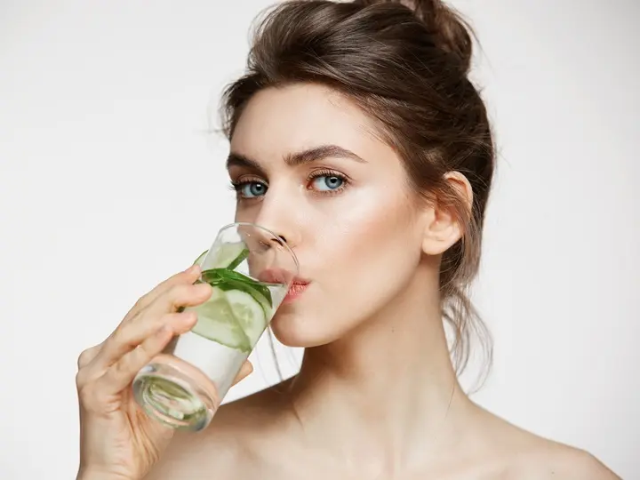 young-beautiful-girl-towel-looking-camera-drinking-water-with-cucumber-slices-white-background-healthy-nutrition-beauty-skincare Hogyan lehet lelassítani az öregedést? Sejtvédelem 