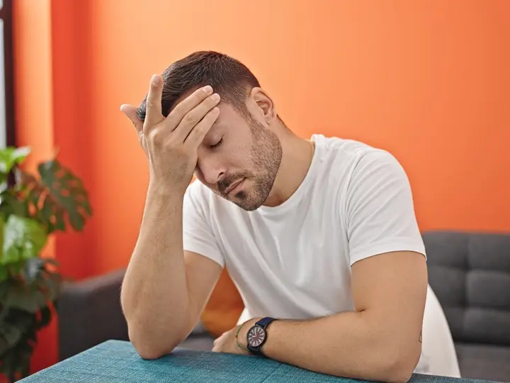 young-hispanic-man-suffering-headache-sitting-table-dinning-room Az okinawai kálcium 5 jótékony hatása Szupertápanyagok 